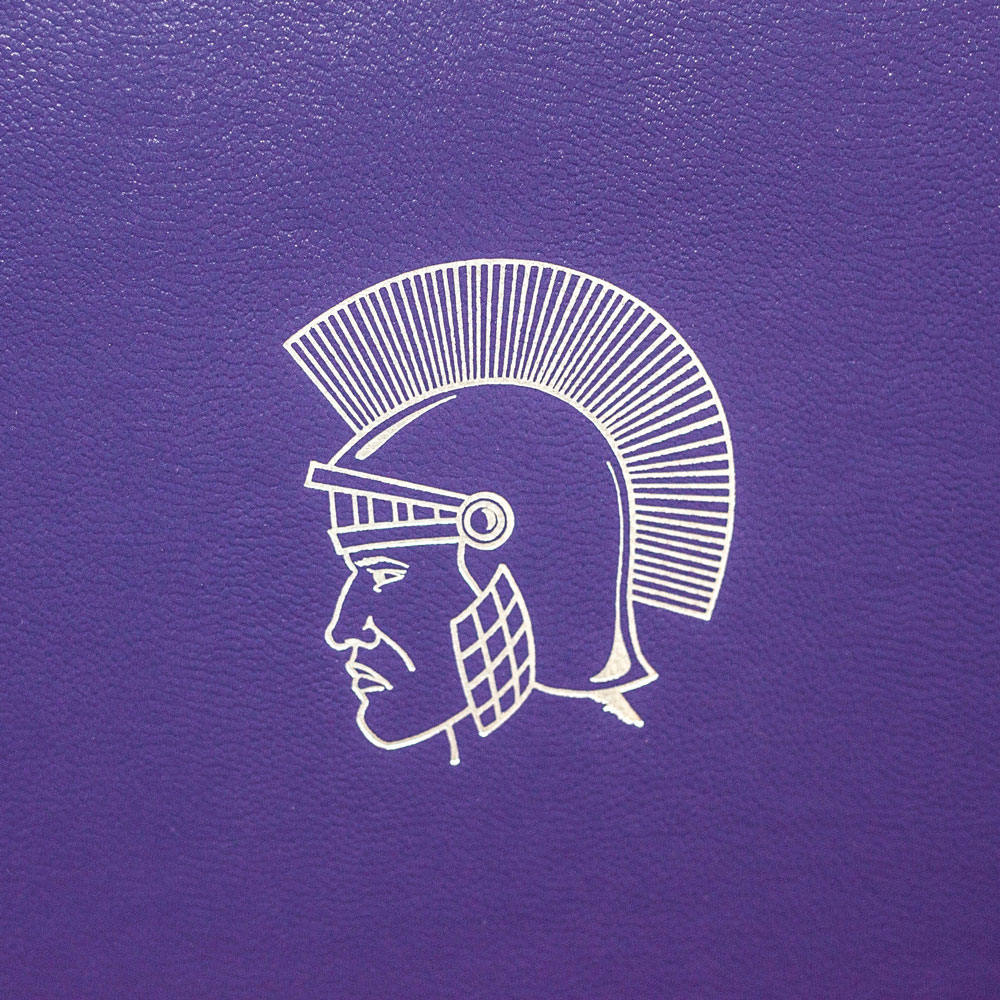 Close-up of a custom foil-stamped Spartan emblem on a purple cover